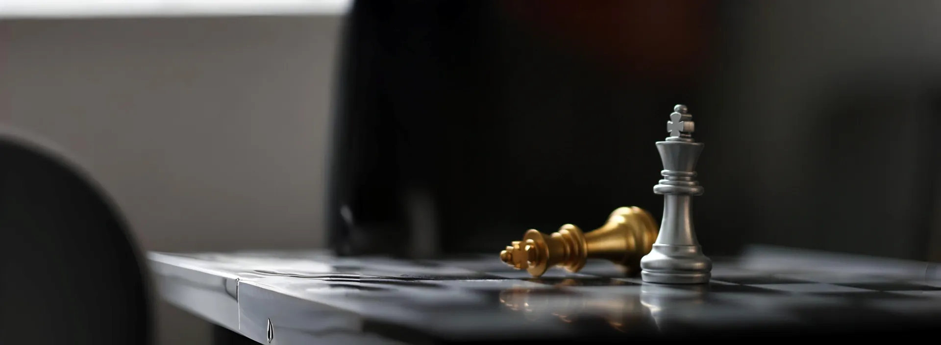 Peças de xadrez dourada e prateada em um tabuleiro, representando a advocacia estratégica de Michele Fonseca.